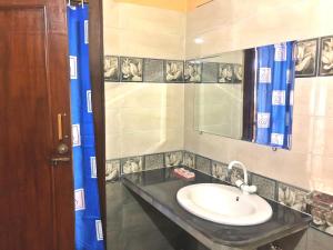 ein Bad mit einem Waschbecken und einem Spiegel in der Unterkunft Babar House in Faisalabad