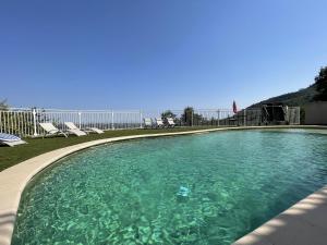 - une piscine d'eau turquoise avec des chaises dans l'établissement Villa Umberto, à Gattières