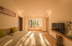 duża sypialnia z łóżkiem i telewizorem w obiekcie Dali Dream House with Seaview w mieście Dali