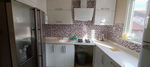 uma cozinha com armários brancos, um lavatório e uma janela em ALTAY MOTEL em Yalova
