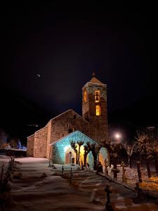 um grande edifício com uma torre de relógio à noite em Allotjament rural Casa Milagros em Barruera