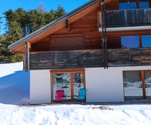 a cabin in the snow with two chairs at Appartement "ENTOURLOUP" classé 2 étoiles in Le Dévoluy