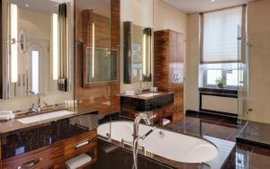 a bathroom with two sinks and a bath tub at Bilderberg Bellevue Hotel Dresden in Dresden
