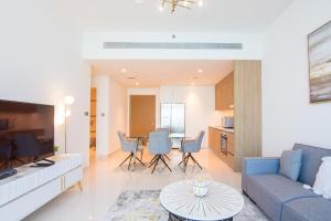 een woonkamer met een blauwe bank en een tafel bij 2BR Amazing Palm View - Private beach - Beach Vista T1 in Dubai