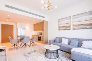 een woonkamer met een bank en een tafel bij 2BR Amazing Palm View - Private beach - Beach Vista T1 in Dubai