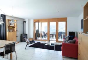 a living room with a red couch and chairs at Just 10min from Lenzerheide - Apartment in Vazerol in Brienz