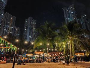 a beach with palm trees and buildings at night at Amberside, Country Garden Danga Bay Homestay by WELCOME HOME in Johor Bahru