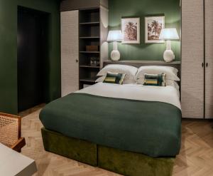 ein Schlafzimmer mit einem großen Bett mit grünen Wänden in der Unterkunft Bellacorte Gentiluogo per Viaggiatori in Parma