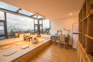 Zimmer mit einem Tisch und einigen Fenstern in der Unterkunft Dali Dream House with Seaview in Dali