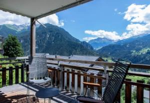 a balcony with two chairs and a view of mountains at Just 10min from Lenzerheide - Apartment in Vazerol in Brienz