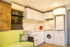 eine Küche mit Waschmaschine und grünem Sofa in der Unterkunft Fi Homes in Izmir