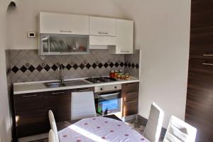 una cucina con tavolo e piano cottura forno superiore di Montegrazie Apartment a Imperia