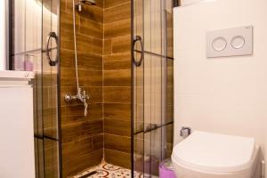 a bathroom with a shower and a toilet at Fi Homes in İzmir