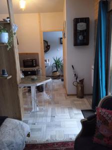een woonkamer met een tafel en een keuken bij Chalet libellule Domaine de la Mamounette in Champclause