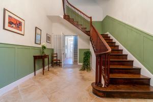 a staircase in a home with green walls at Leonard Stanley House in Stonehouse