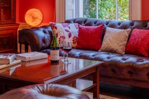 a living room with a couch and a bottle of wine on a table at Leonard Stanley House in Stonehouse