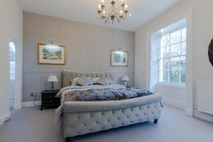 a bedroom with a large bed and a chandelier at Leonard Stanley House in Stonehouse