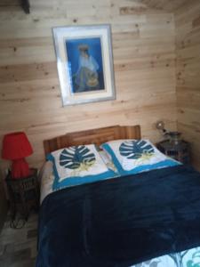a bedroom with a bed and a picture on the wall at Chalet Cricri Domaine de la Mamounette in Champclause