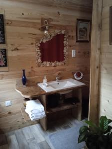 a bathroom with a sink in a log cabin at Chalet Cricri Domaine de la Mamounette in Champclause