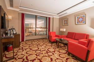 a hotel room with red chairs and a living room at Taiba Madinah Hotel in Medina