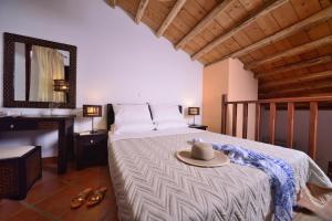 a bedroom with a bed with a hat on it at The Varos Residences Hotel in Város