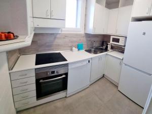 a white kitchen with a stove and a sink at Dehesa Centro con Parking in Soria