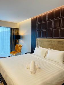 a hotel room with a large bed with towels on it at Platinum Suites Tower 2 KLCC in Kuala Lumpur