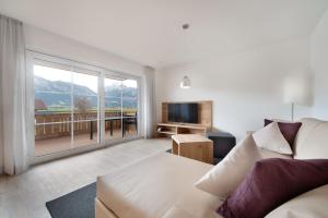 a living room with a couch and a television at Landhaus am See Appartement LH 03 in Schwangau