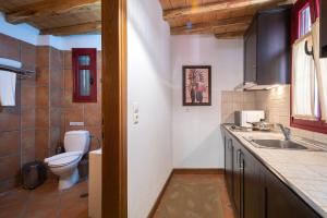 a bathroom with a toilet and a sink at The Varos Residences Hotel in Város