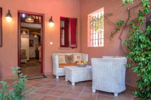 a porch with a couch and chairs and a table at The Varos Residences Hotel in Város