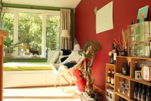 sala de estar con paredes rojas y sofá blanco en Chez Madame Irma, en Aywaille