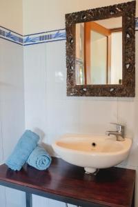 a bathroom with a sink and a mirror at Mancur Guesthouse in Ubud