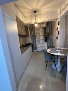 a kitchen with a table and a dining room at Apartament Craiova Magnolia in Craiova