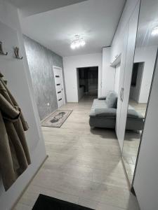 a living room with a couch and a mirror at Apartament Craiova Magnolia in Craiova