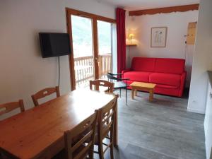 a living room with a red couch and a table at Les Balcons PROCHE PARC NATIONAL VANOISE appartements 2 pieces 5 pers in Termignon