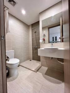 La salle de bains est pourvue de toilettes, d'un lavabo et d'un miroir. dans l'établissement LAMI homestay - Căn hộ nghỉ dưỡng thư giãn và thú vị, à Hanoï