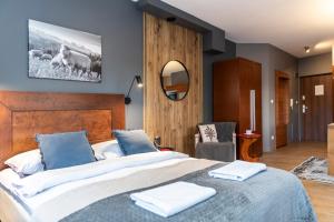 sypialnia z dużym łóżkiem z dwoma ręcznikami w obiekcie TatryTop Pod Skocznią w Zakopanem