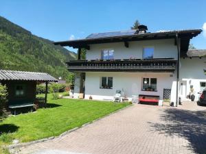 a large white house with a grass yard at Appartement Lengdorfer in Untertauern