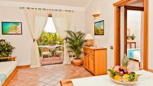 普拉的住宿－Residence Baia delle Palme，客厅配有沙发和桌子