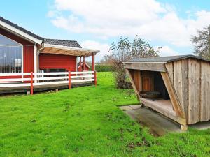 a wooden dog house in a yard next to ashed at 6 person holiday home in Vinderup in Vinderup