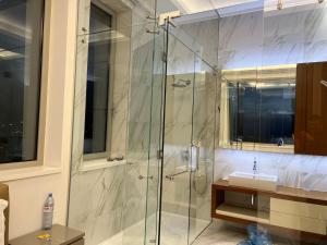 a bathroom with a glass shower with a sink at Olympic Residence Deluxe Apartments in Limassol
