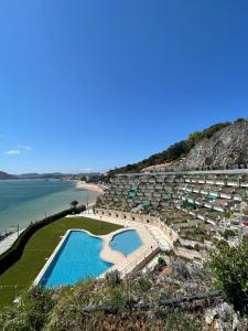 un complexe avec une piscine à côté d'une plage dans l'établissement Residencial Vistamar, à Santoña