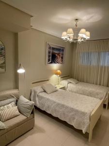 a hotel room with two beds and a couch at Residencial Vistamar in Santoña