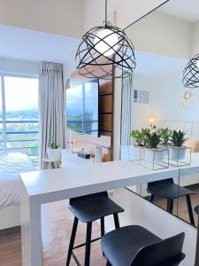 a kitchen and living room with a white table and chairs at Studio with mountain view, near Limketkai mall in Prime Cagayan de Oro in Cagayan de Oro