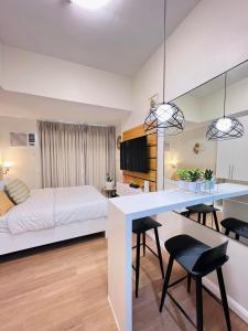 a bedroom with a bed and a table and chairs at Studio with mountain view, near Limketkai mall in Prime Cagayan de Oro in Cagayan de Oro