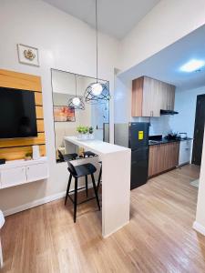 a kitchen with a white counter and a black refrigerator at Studio with mountain view, near Limketkai mall in Prime Cagayan de Oro in Cagayan de Oro