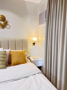 a bedroom with a bed and a window with curtains at Studio with mountain view, near Limketkai mall in Prime Cagayan de Oro in Cagayan de Oro