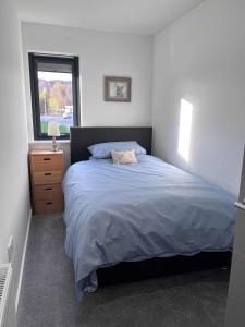 a bedroom with a large bed and a window at Caledonia Place in Aviemore