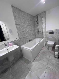 a bathroom with a tub and a sink and a toilet at Caledonia Place in Aviemore +3 photos