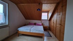 een kleine slaapkamer met een bed met paarse kussens bij FeWo 1 Rolf Koglin in Gunzenhausen